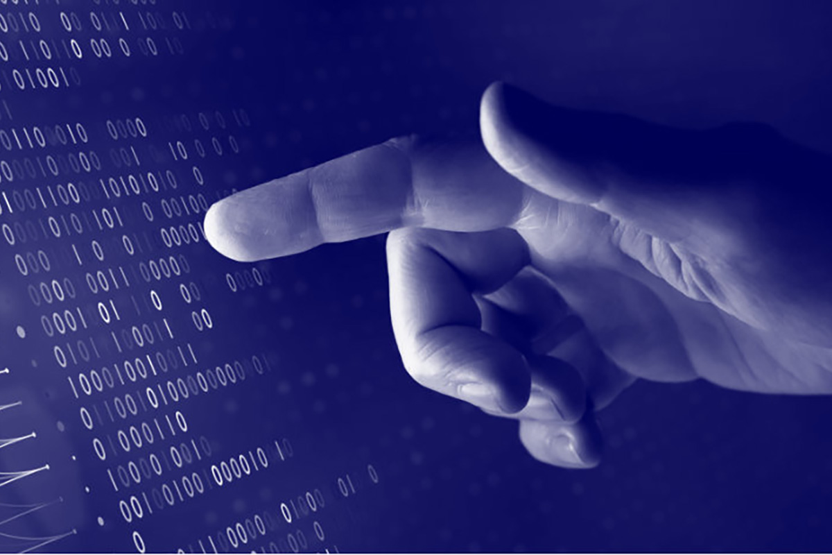 A hand touching a computer screen displaying binary code