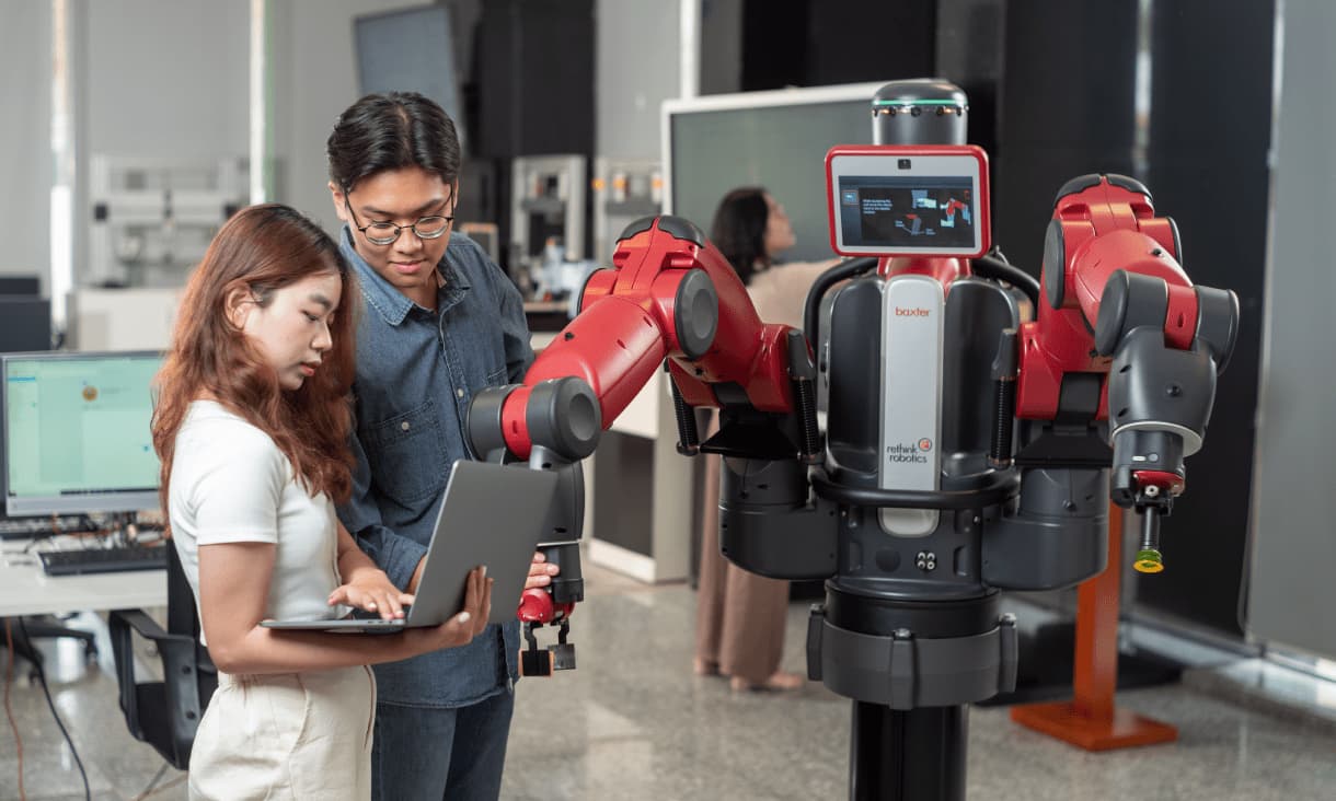 two students inspecting a robot