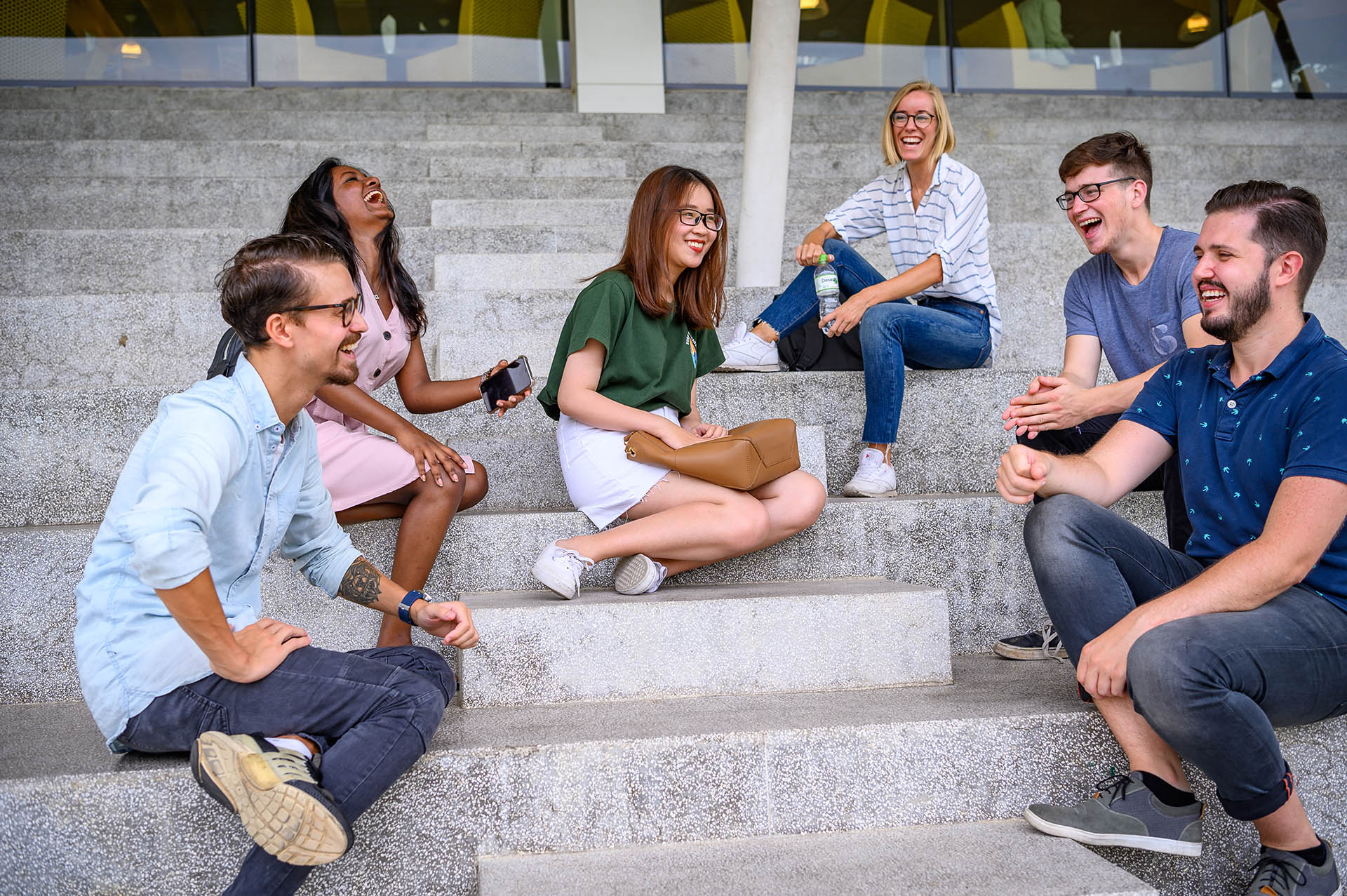 international students sitting and chatting on white stairs