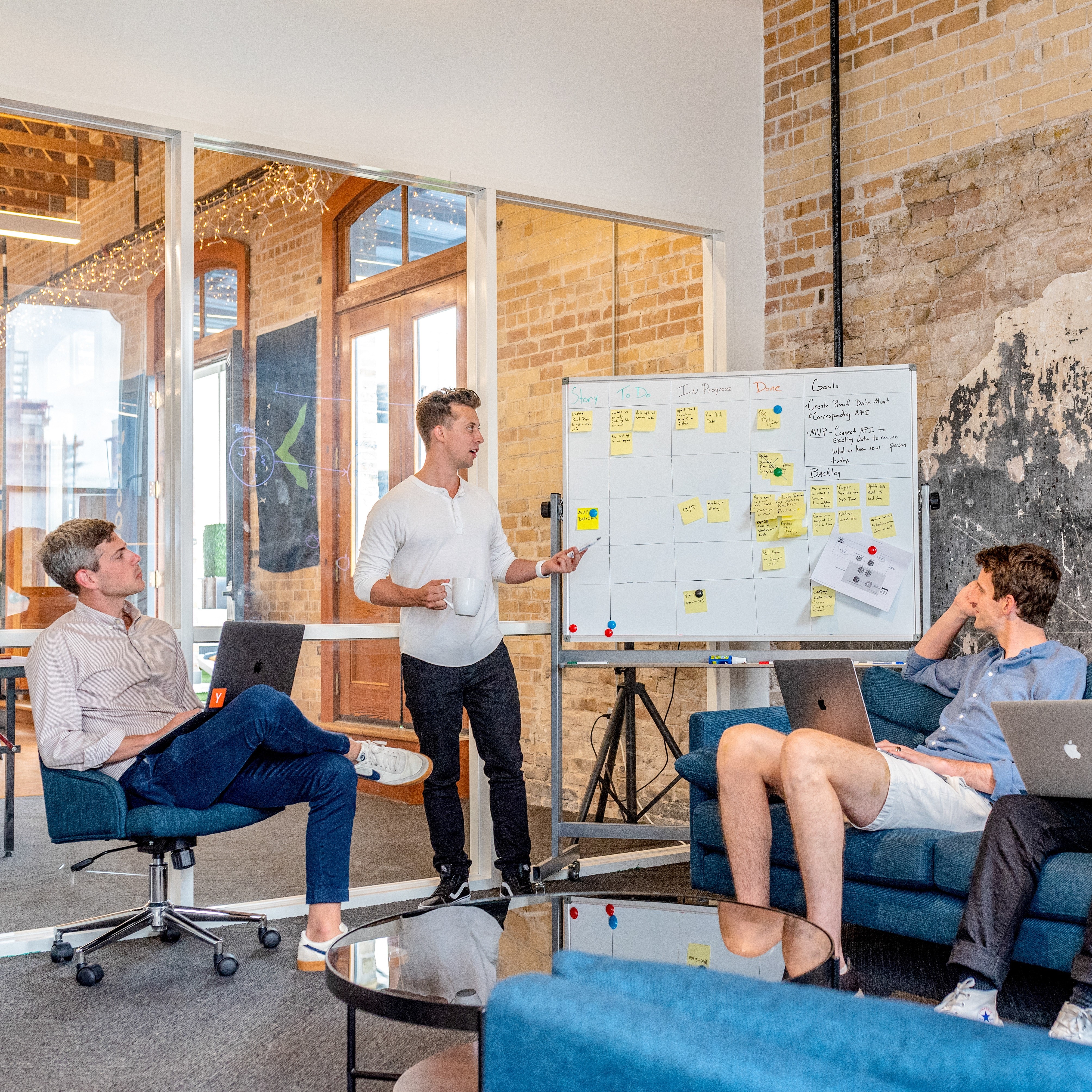 People discussing work near a whiteboard.
