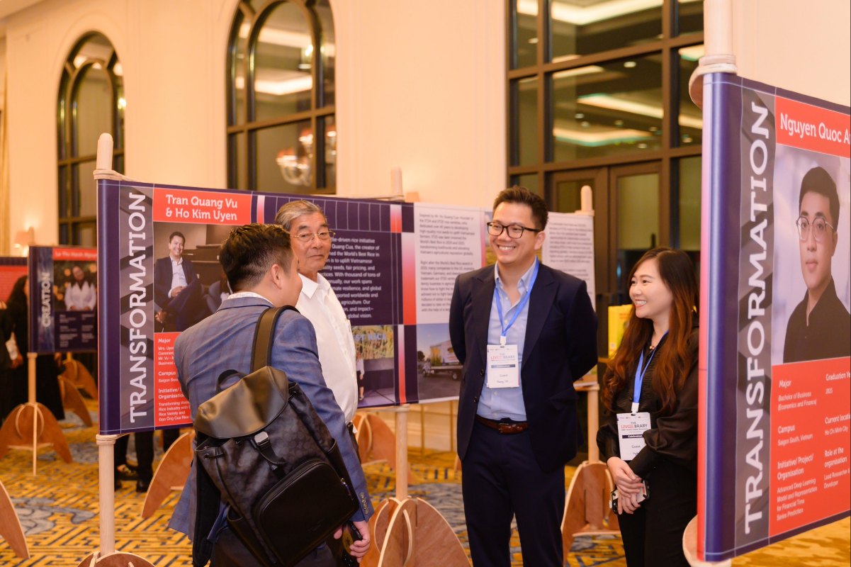 Four people discussing and smiling in the middle of the ballroom