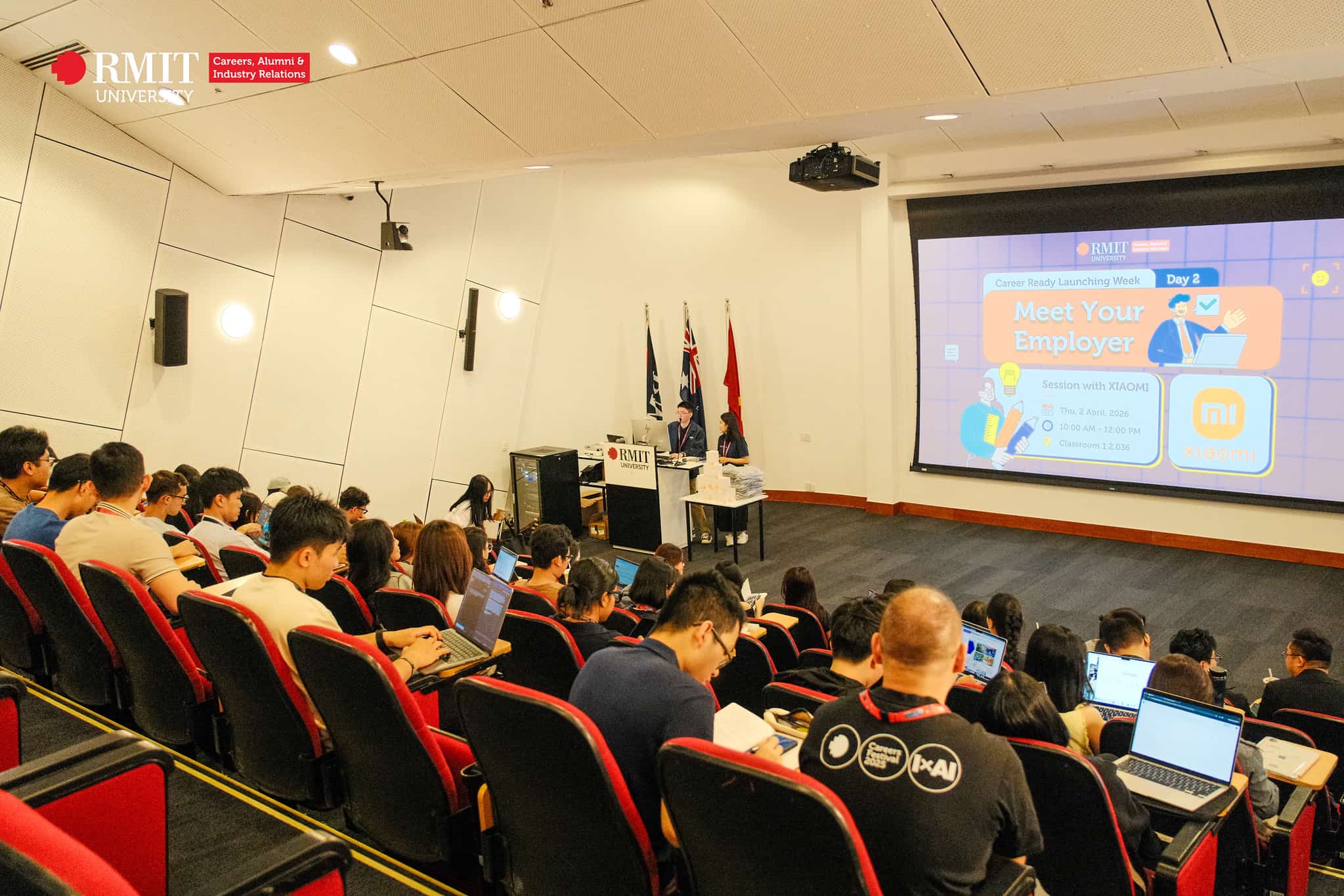 Audience seated in a lecture hall focusing on a presentation