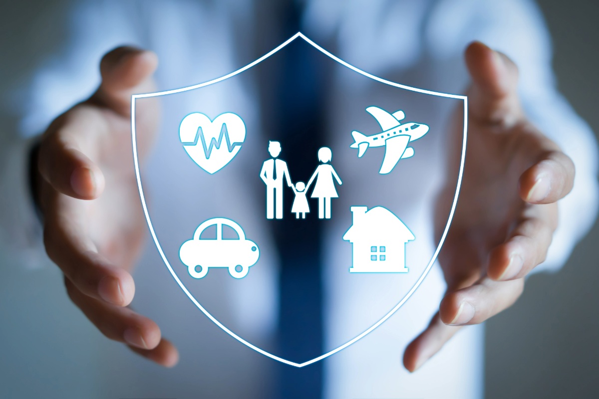Hands holding a digital shield with icons representing insurance coverage: health, family, travel, car, and home protection.