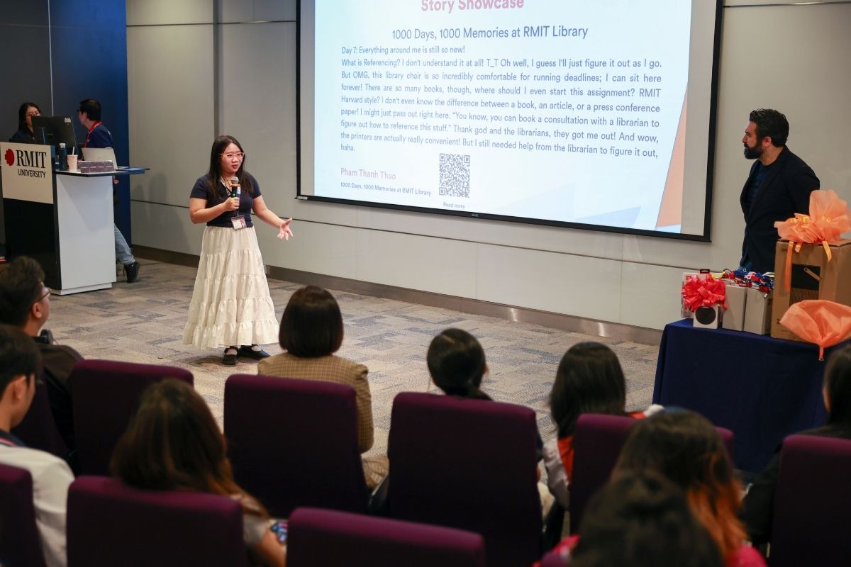 The photo showing a girl giving a presentation in front of a class in an hallroom
