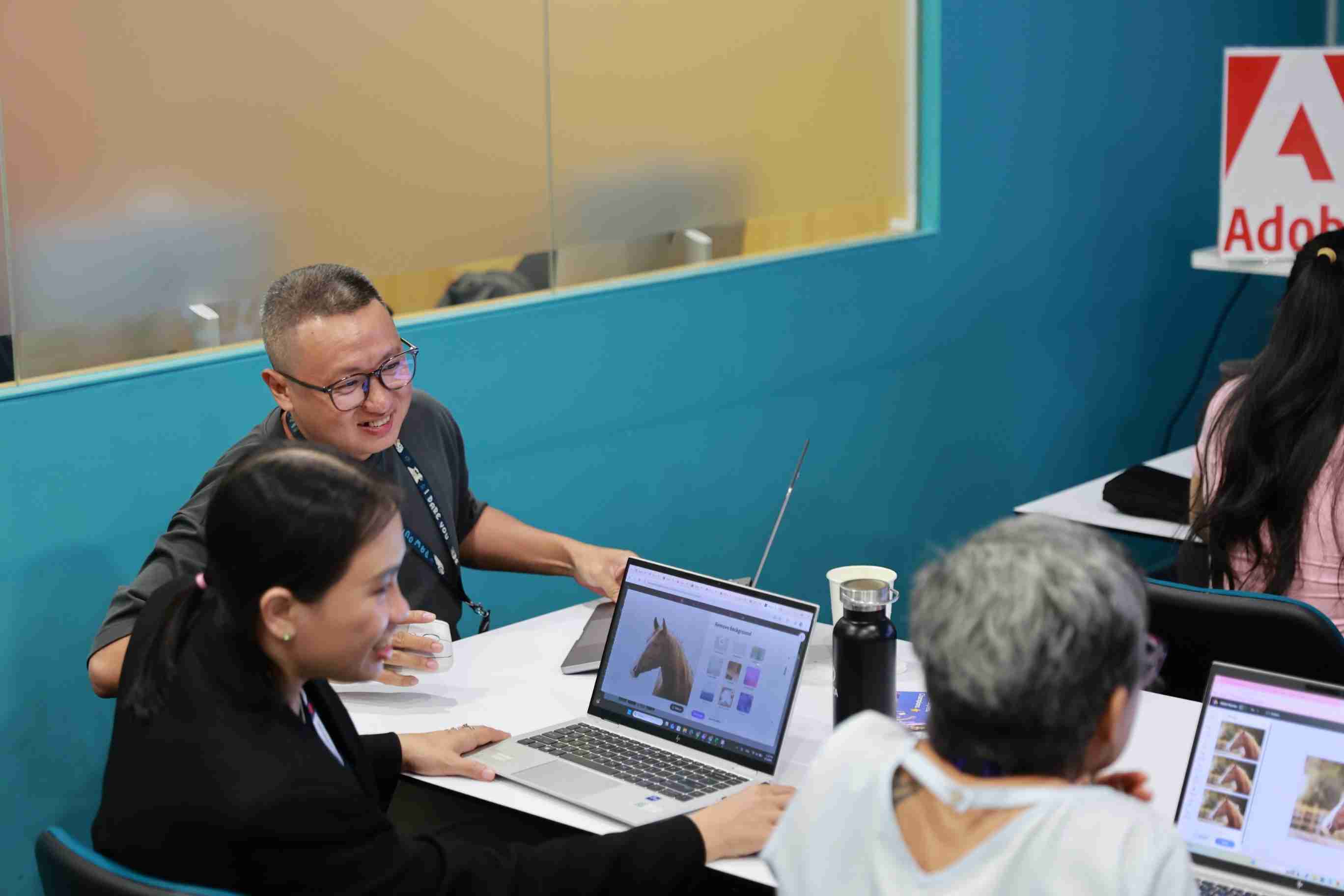 the photo showing a group of people working on computers, looking happy