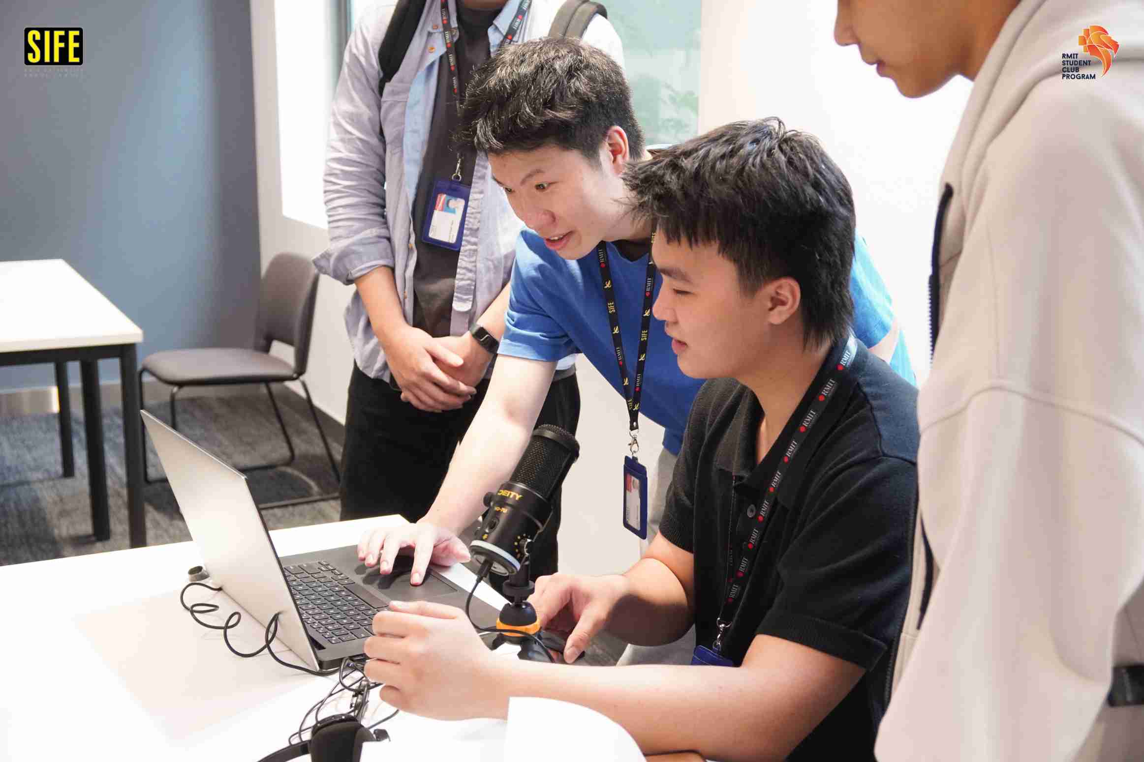 a photo showing 2 male teenagers browsing laptop