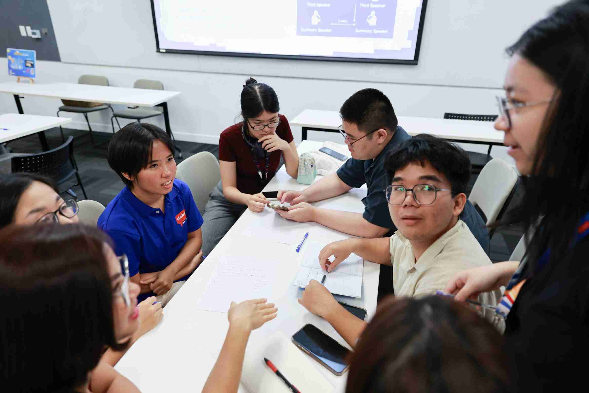 the photo showing a group of students discussing together