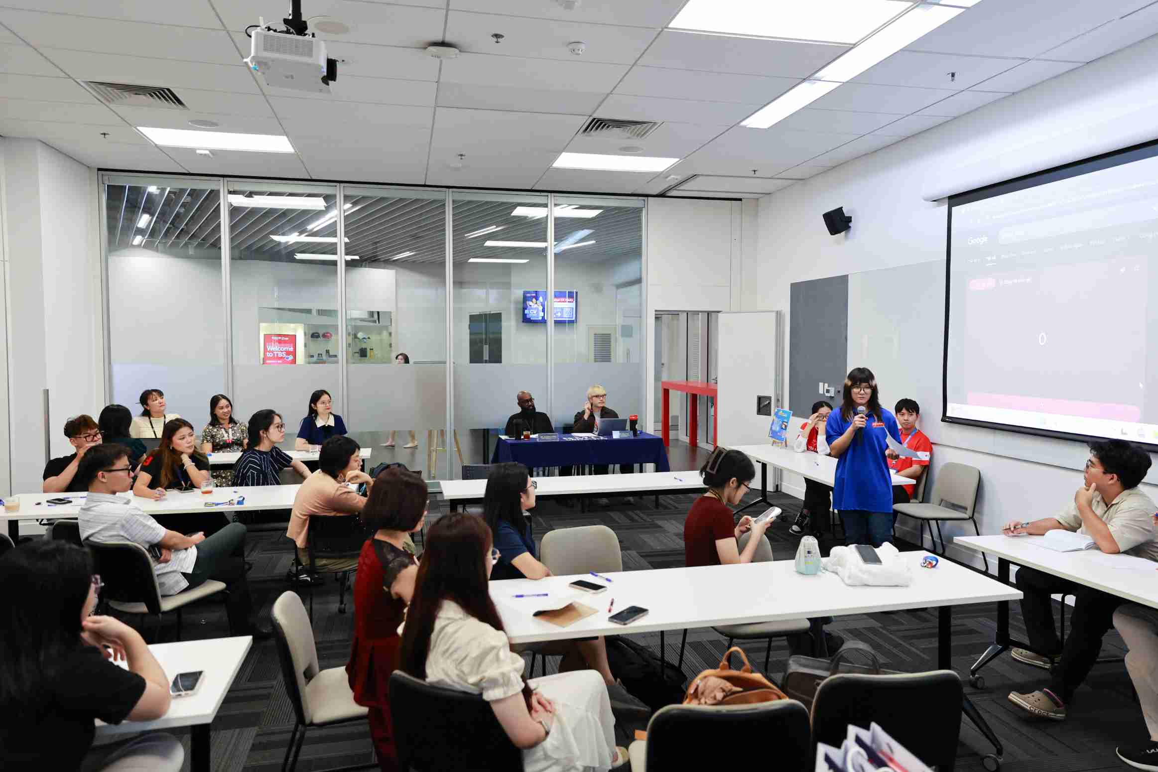 the photo showing a girl presenting in front of classroom