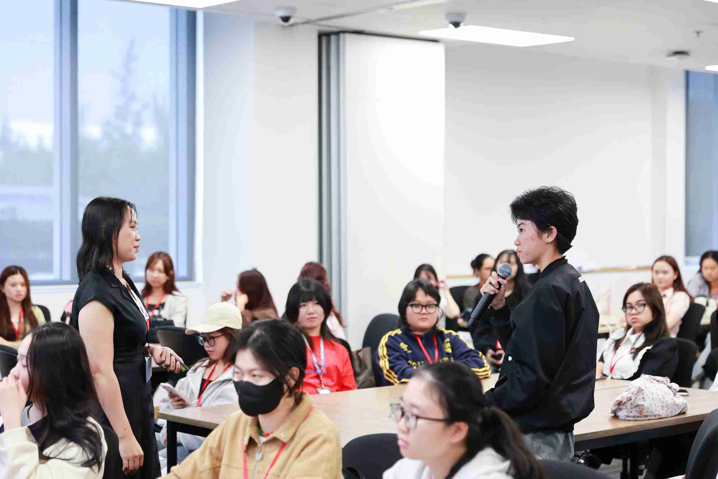 photo of two persons giving conversation among other people