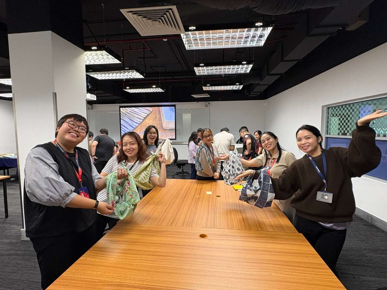 Group of people gathered around a conference table smiling and posing for a photo.