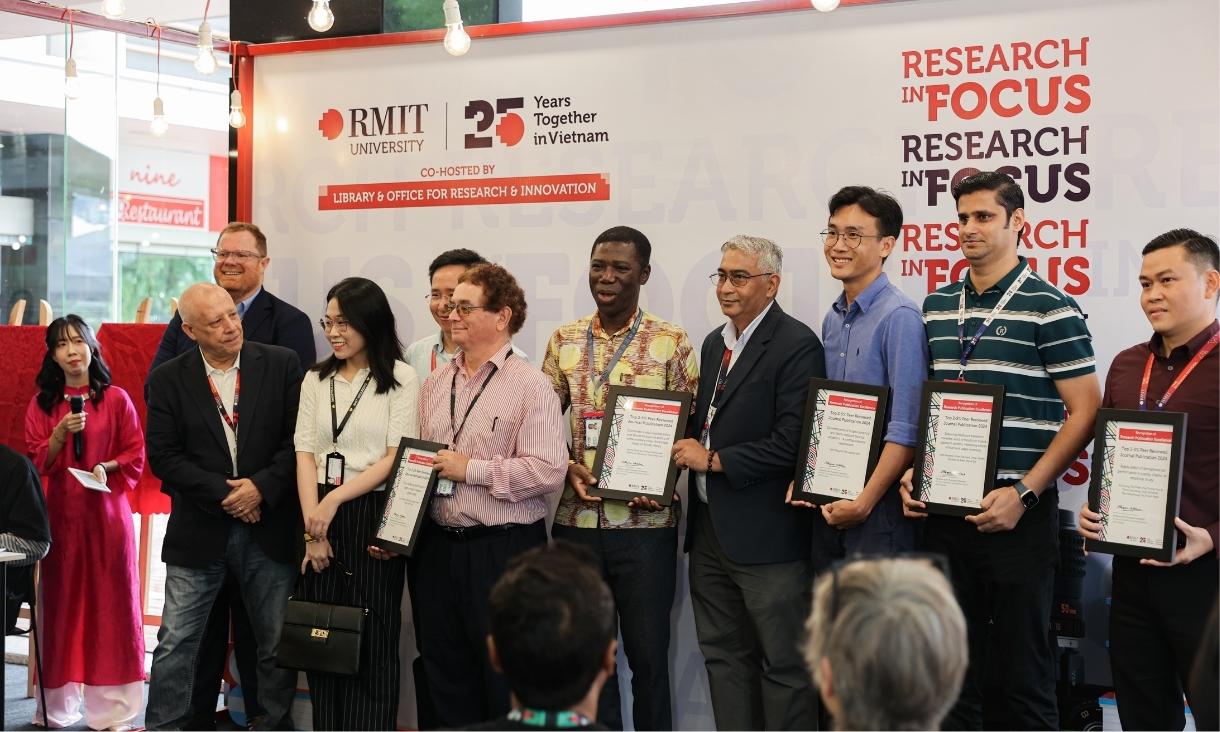 The photo of a group of men, dressing formally, posing for a group photo while holding a certificate.