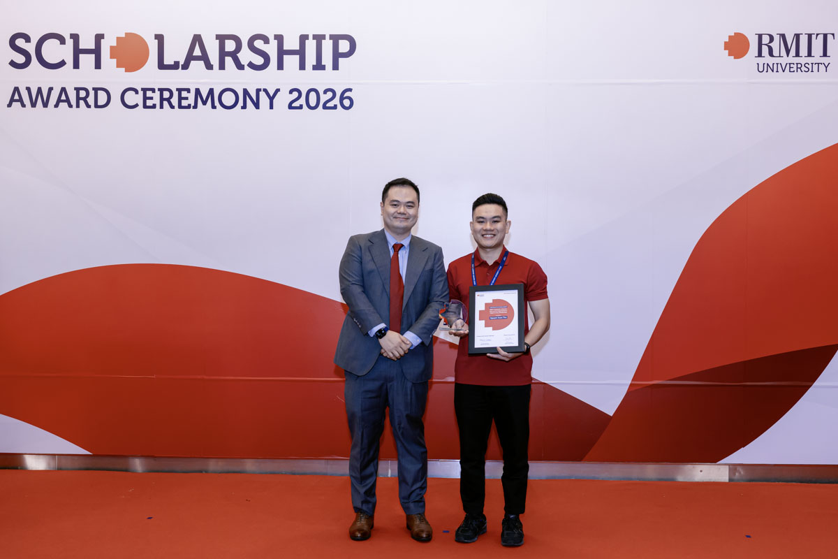 Two people standing on stage at the RMIT University Scholarship Award Ceremony 2026, with one holding an award and framed certificate.