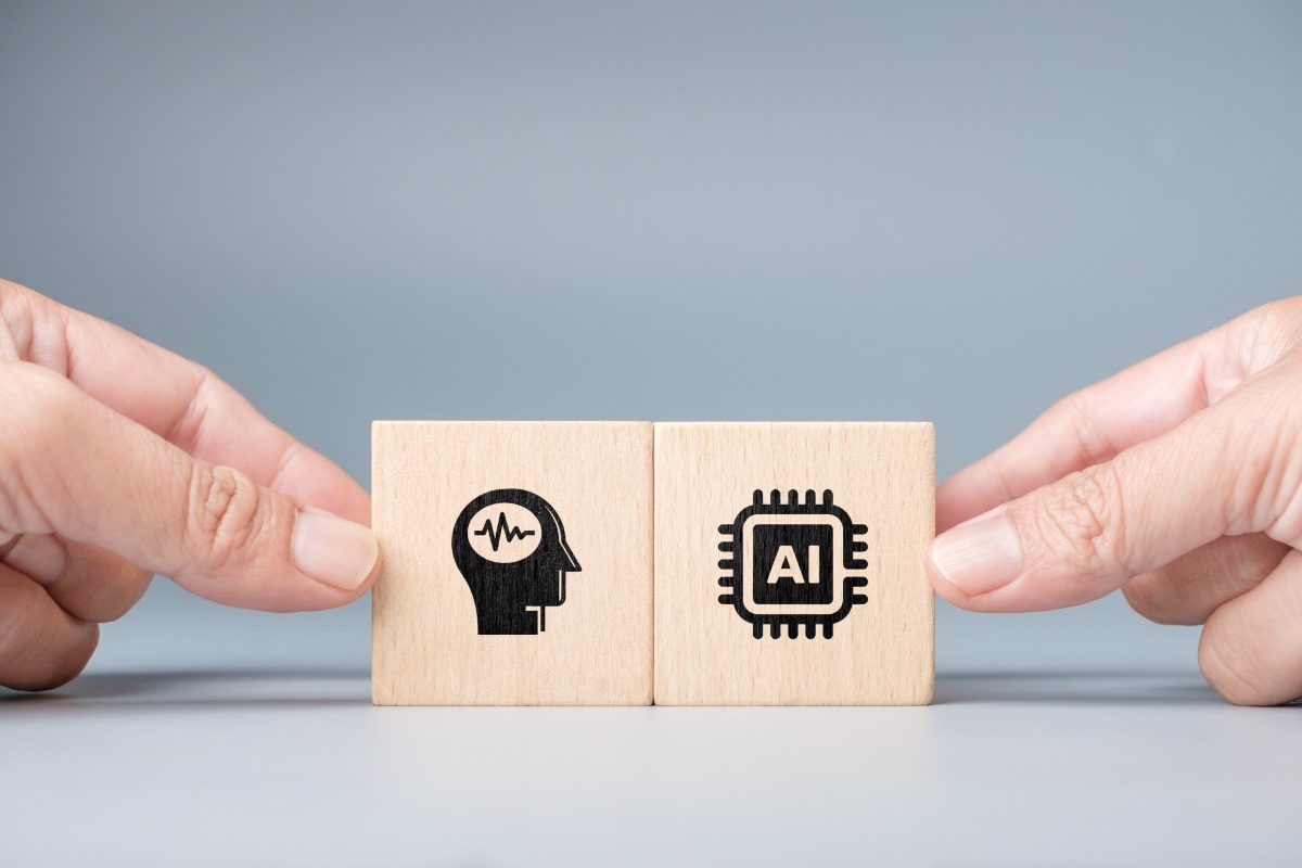 A wooden block showing a human skull and another block showing AI