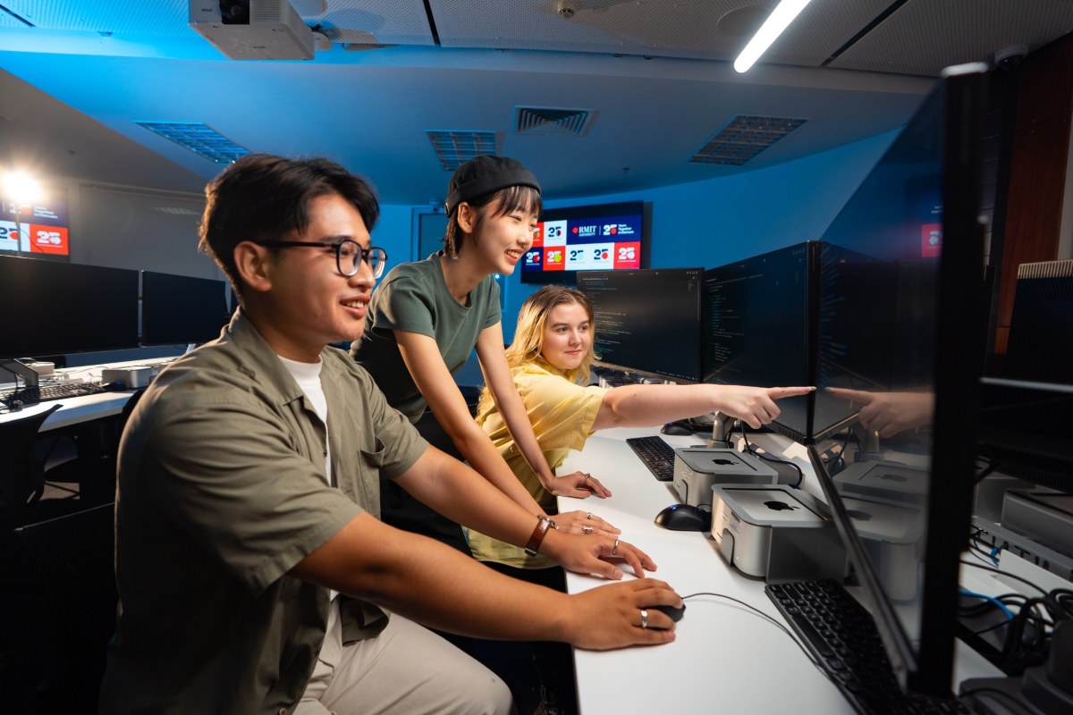 Three students looking at a computer screen