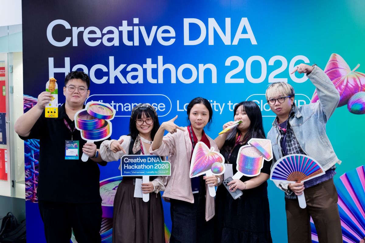 Students posing in front of an event backdrop