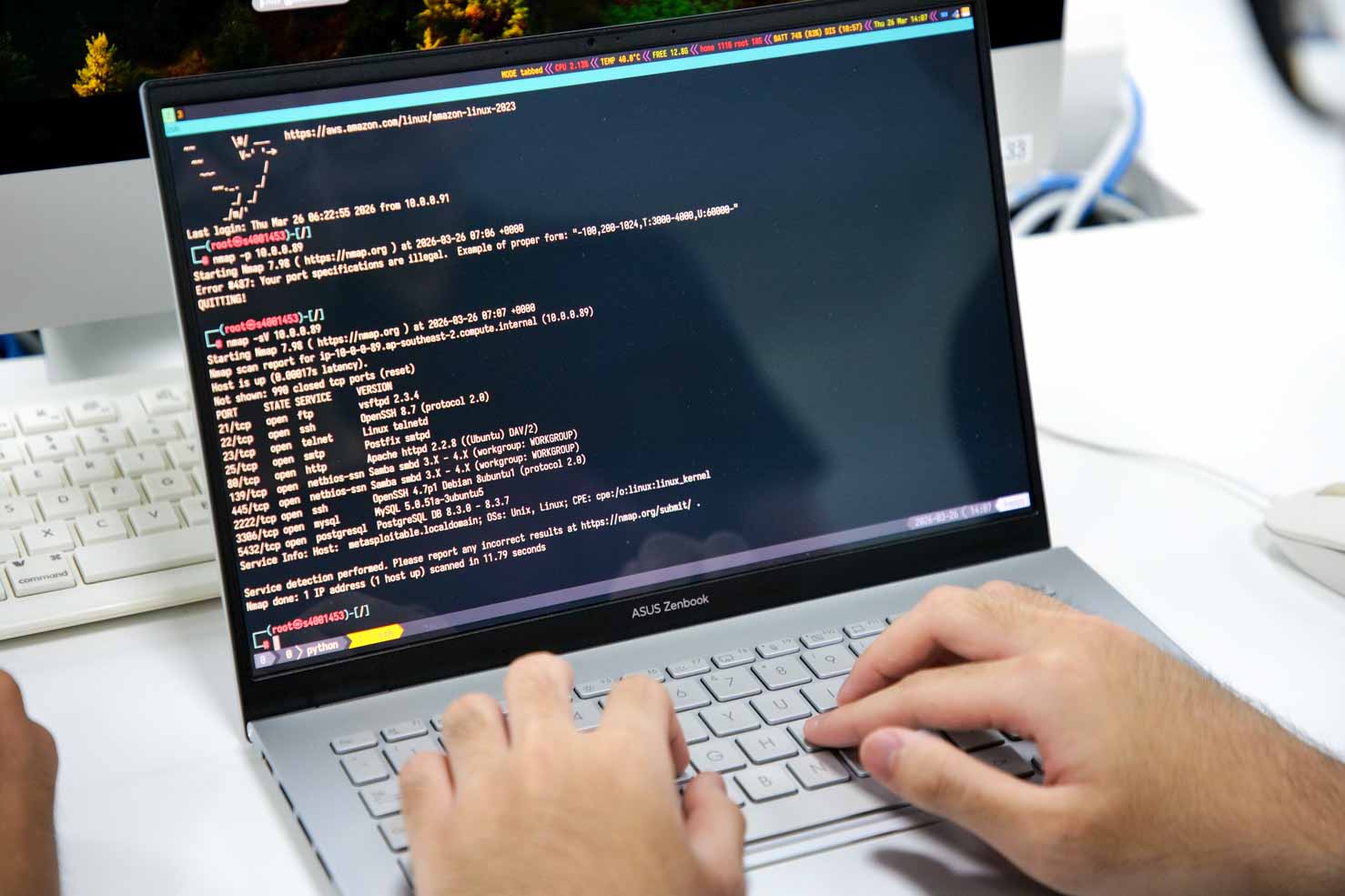 Hands typing on a laptop showing lines of code in a terminal window.