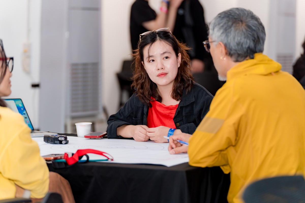 Three people chatting around a table
