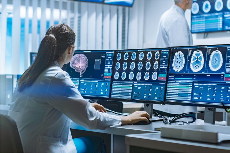 Doctor watching brain scans on a computer screen