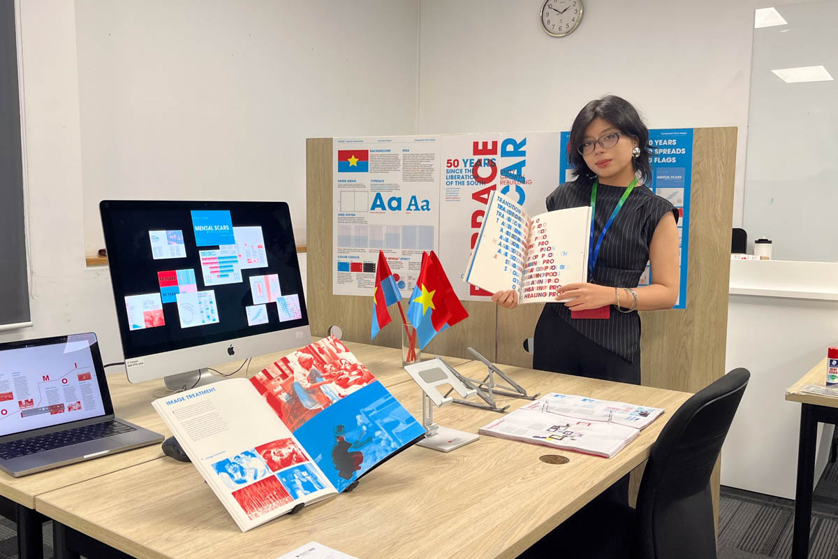 Giang standing next to her work