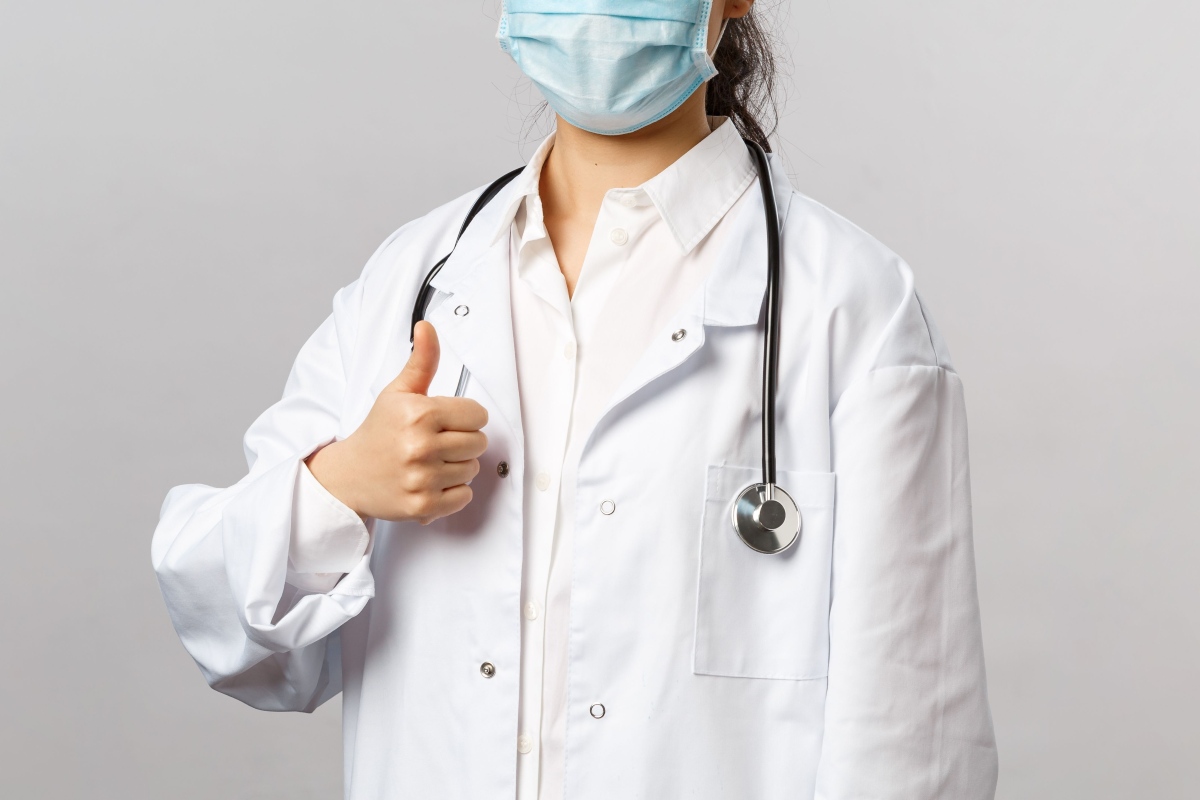 Medical professional holding a thumb up