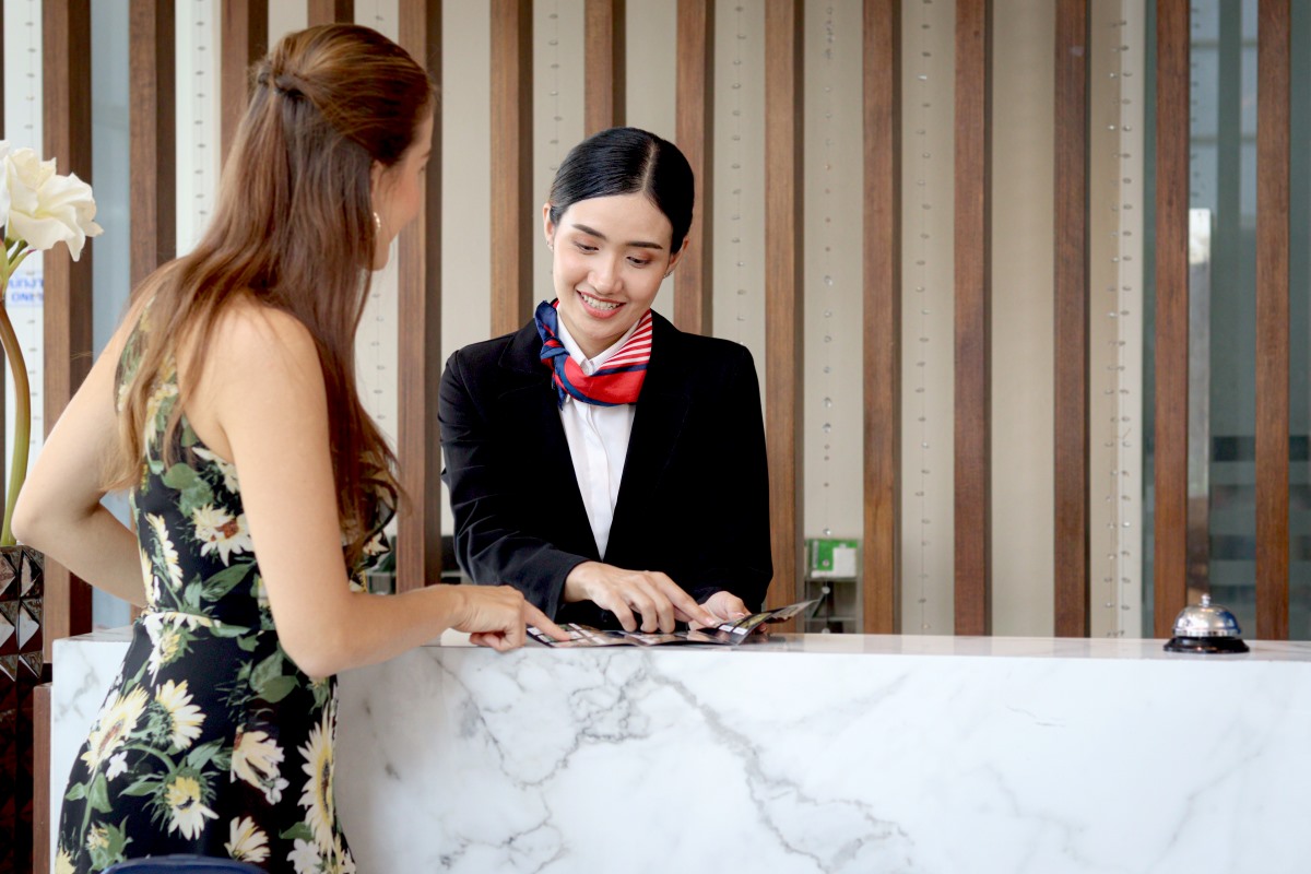 Hotel receptionist talking to guest