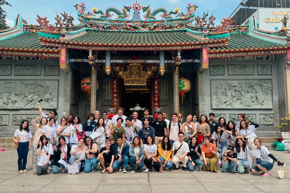 Students posing in front of a temple