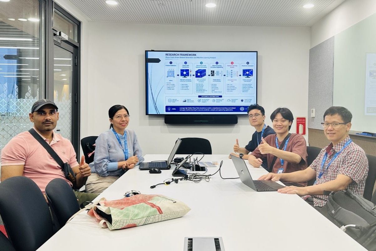 Photo of 5 people sitting around a table in a meeting room