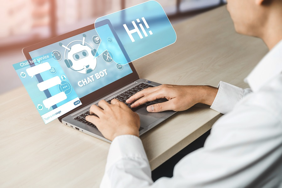 Man typing on a laptop with a chatbot