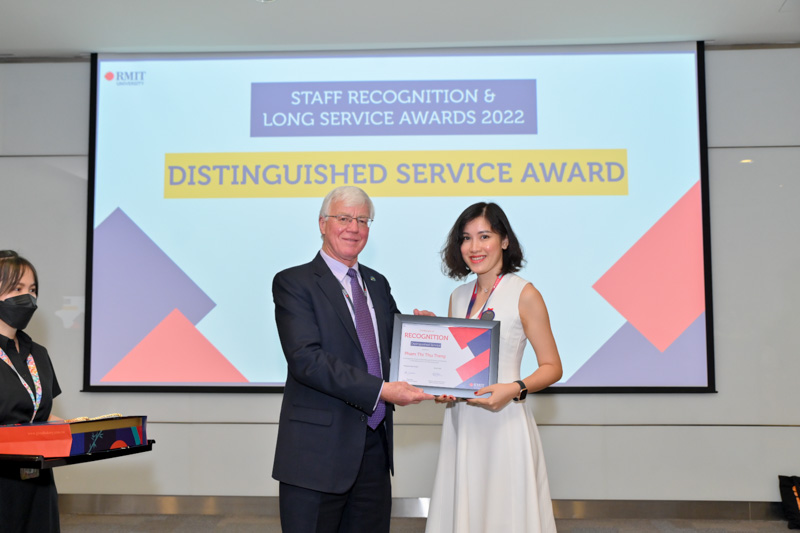 RMIT Vietnam Chairman Professor Peter Coloe giving a Distinguished Service Award to Ms Pham Thi Thu Trang from Student Connect.