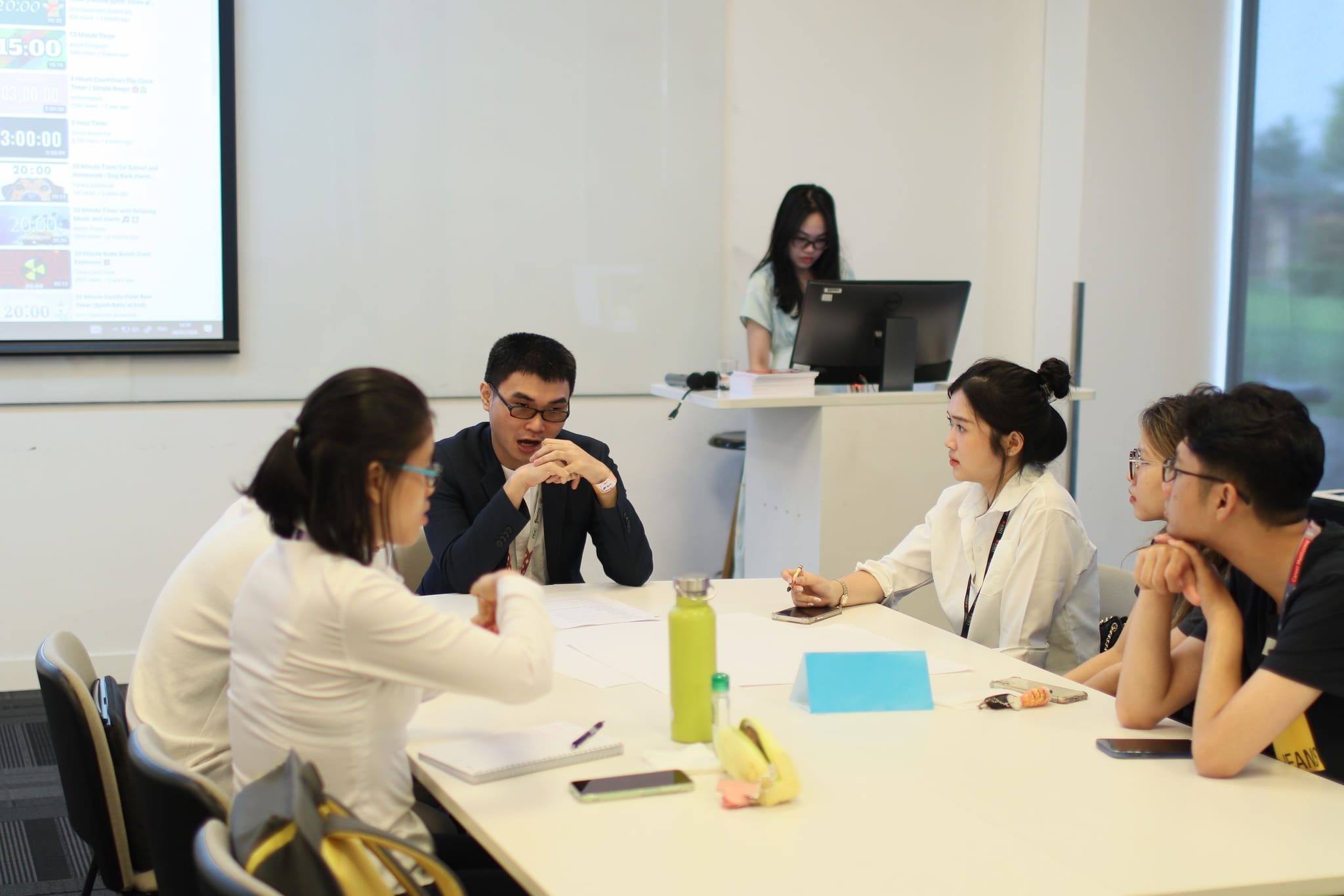 Minh sitting at a table with 5 other young people