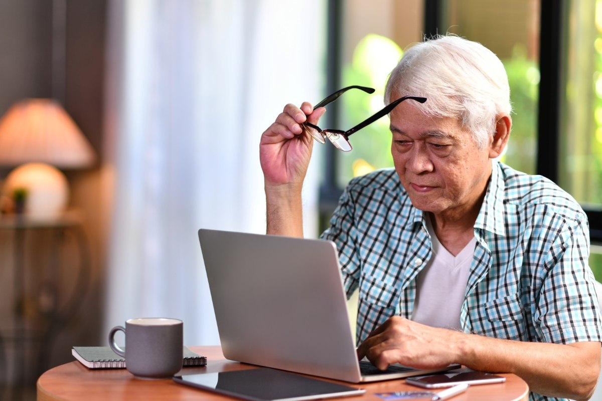Elderly man looking at a laptop