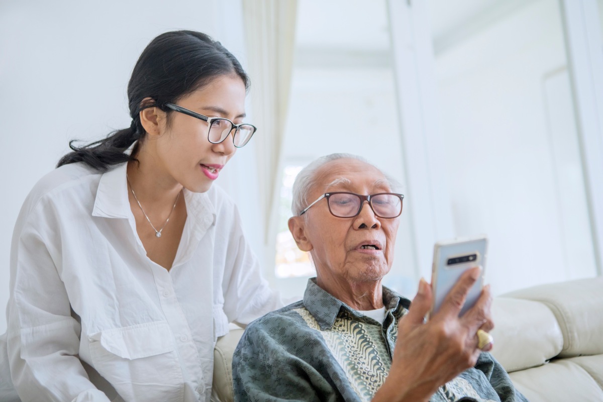 An old man and a woman looking at a smartphone