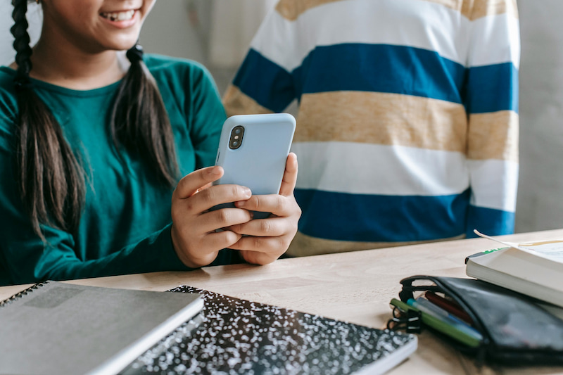 Two adolescents looking at a smartphone