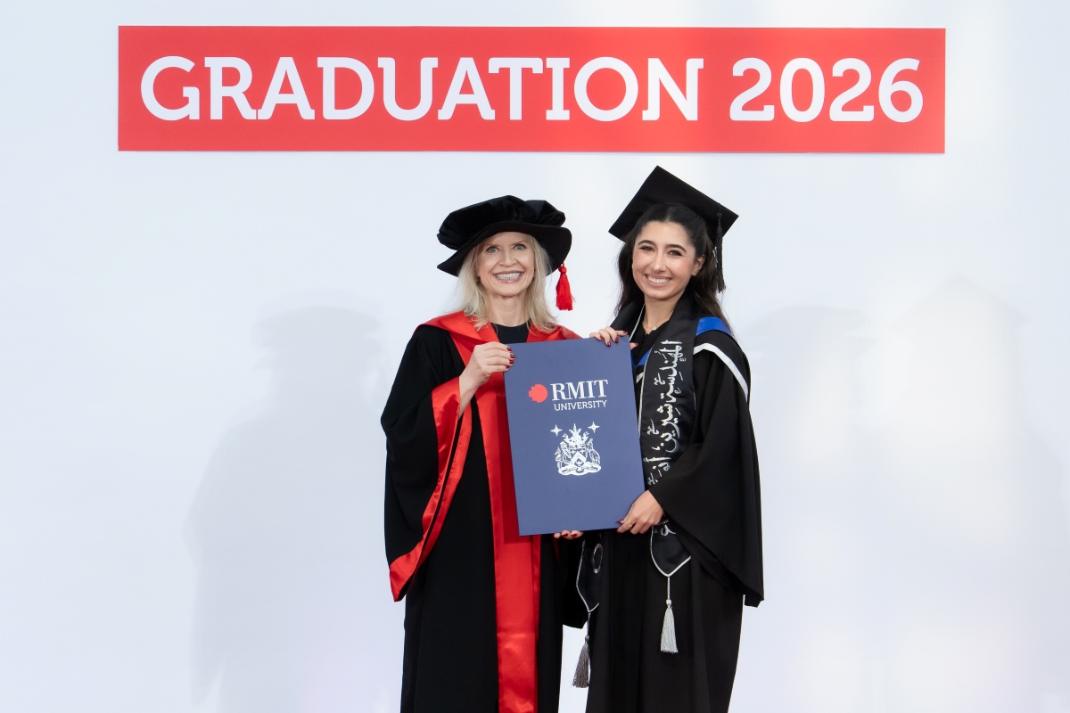Shurin Shujaa is graduating with a Master of AI, stand smiling together with an RMIT University certificate in front of a "Graduation 2026" backdrop.