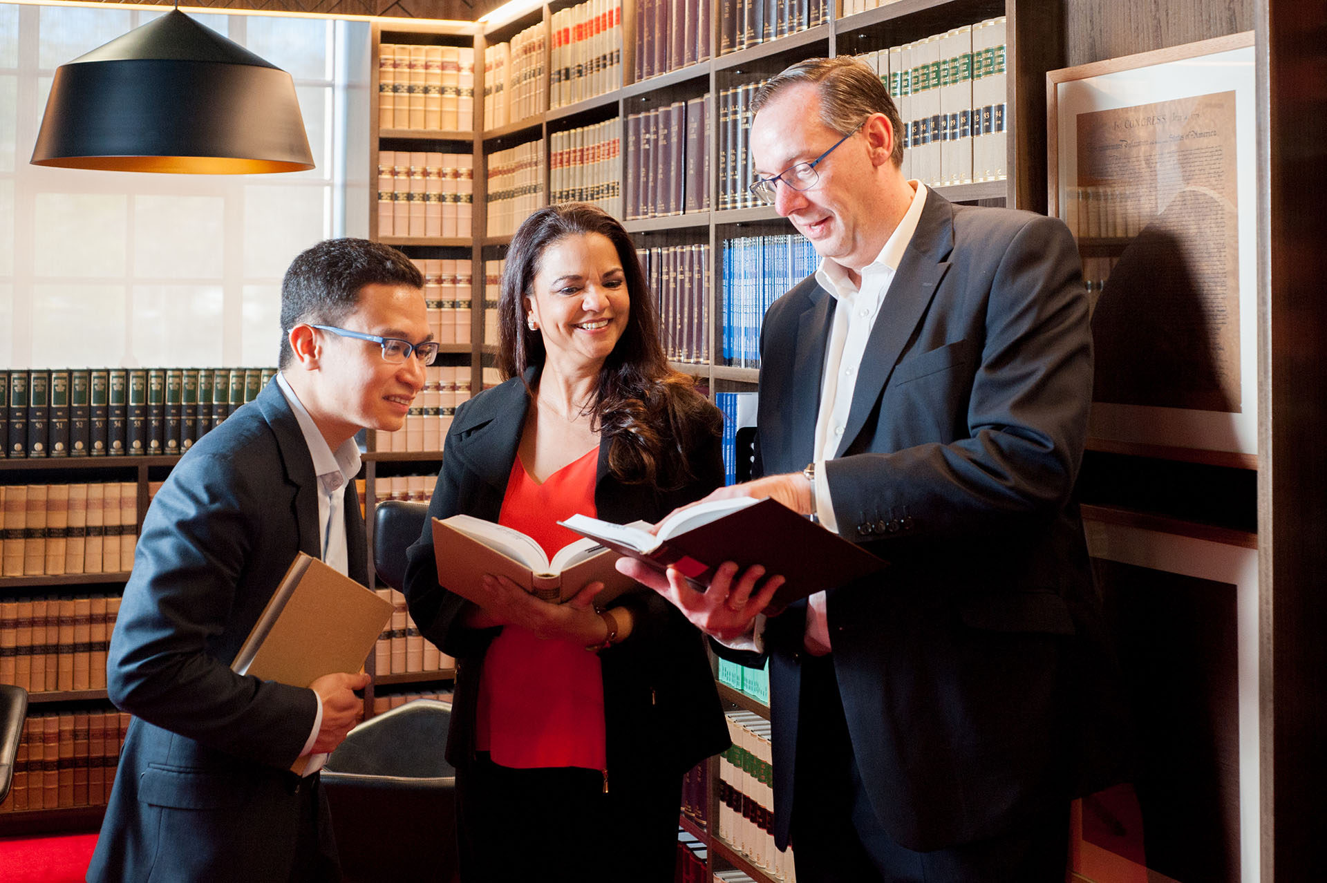 The back of a student sitting at a desk, with shelves of books on both sides