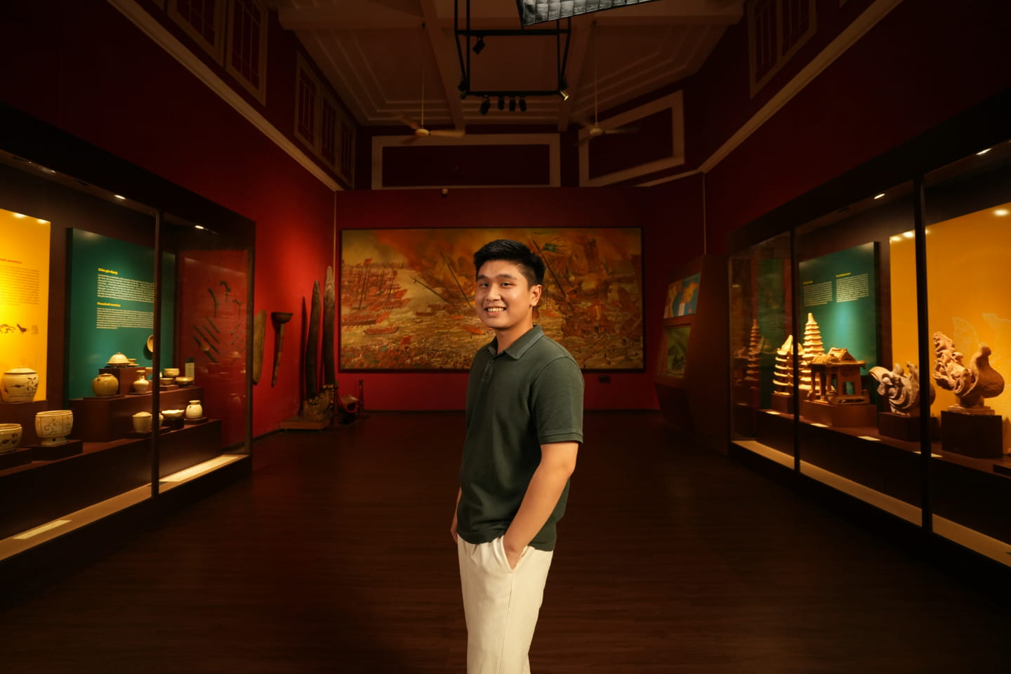 RMIT alumnus Pham Quang Vinh standing and smiling inside a museum exhibition room