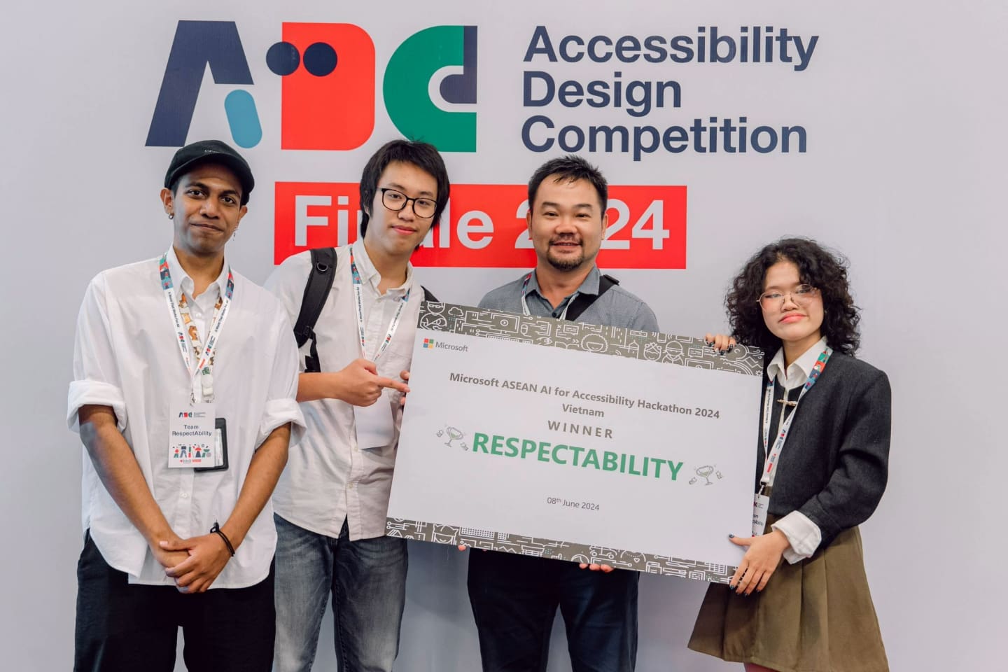 Team from RMIT Vietnam holding a "Winner" certificate for the Microsoft ASEAN AI for Accessibility Hackathon 2024 in front of the event's banner.