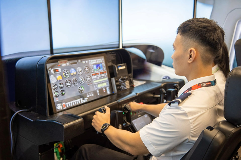 Photo of two RMIT students training with a flight simulator 