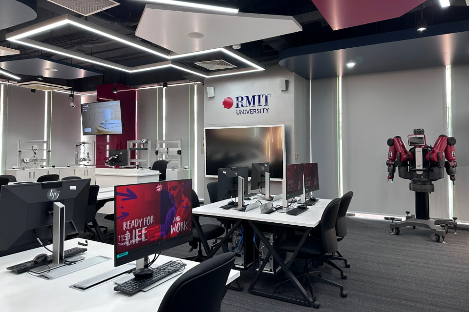 Photo of an electronic lab featuring the Baxter robot and didactic plc system with computer stations throughout the lab