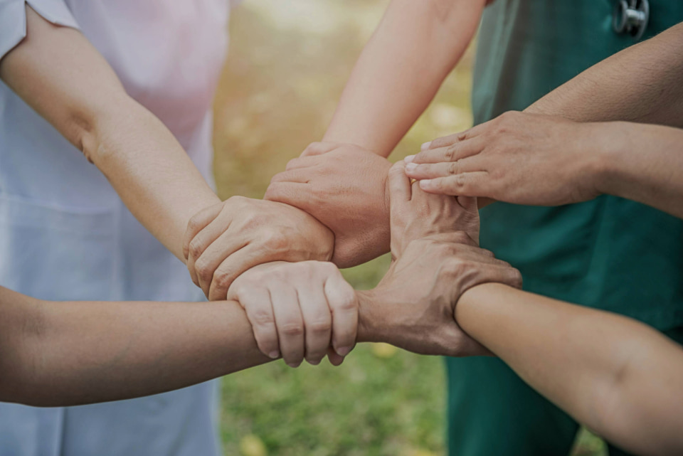 Photo of a group of people putting their hands together