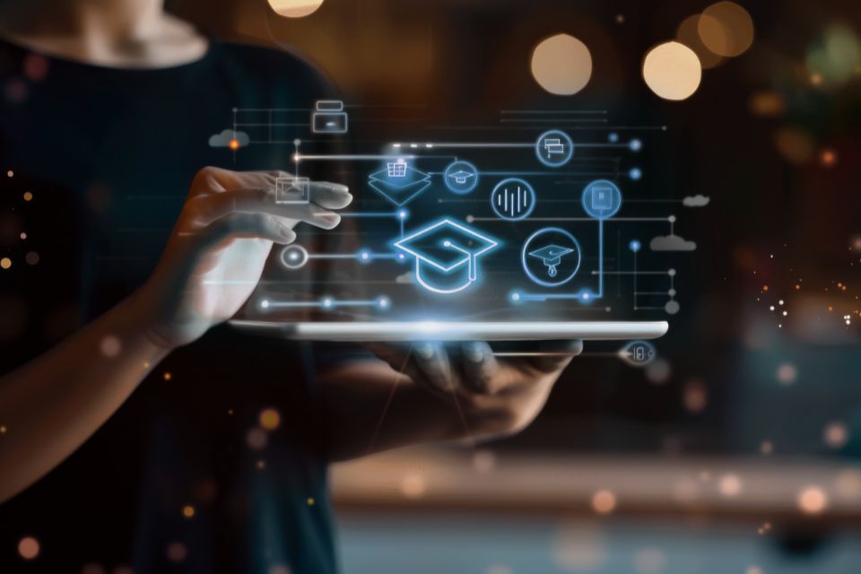 Photo of a person interacts with a tablet displaying digital icons related to education, including a graduation cap