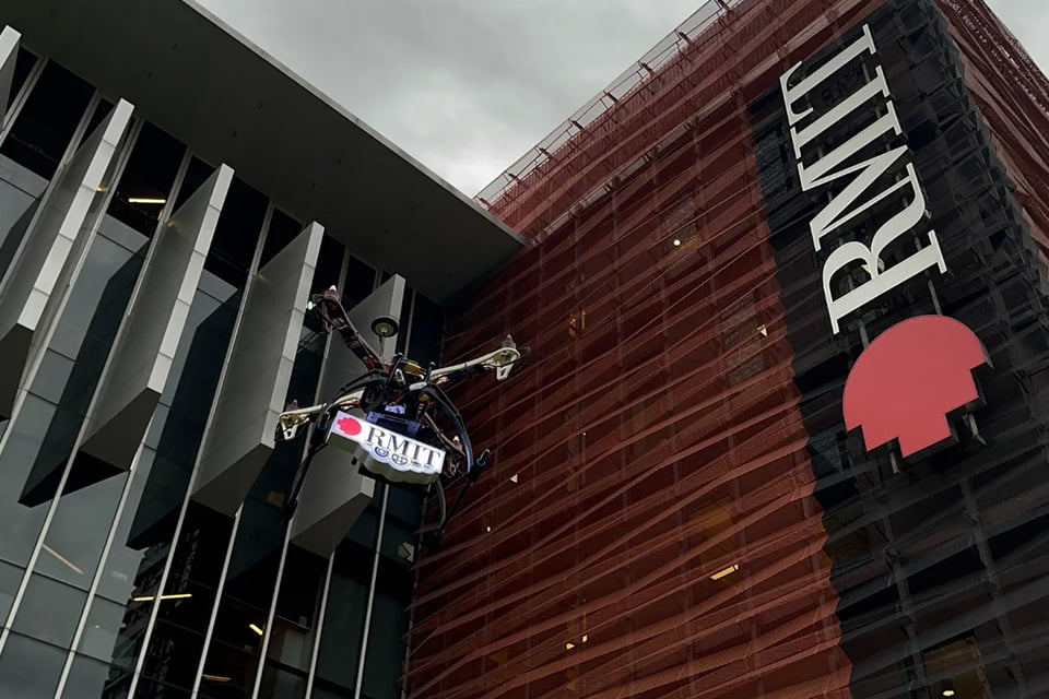 Drone flying within the vicinity of RMIT Saigon South campus, holding an RMIT signage