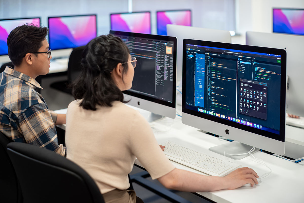 Hai sinh viên đang lập trình trên máy tính