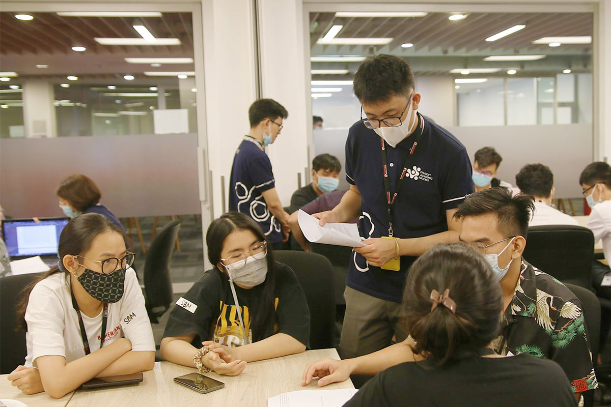 male student tutor supporting a group of other students on homework