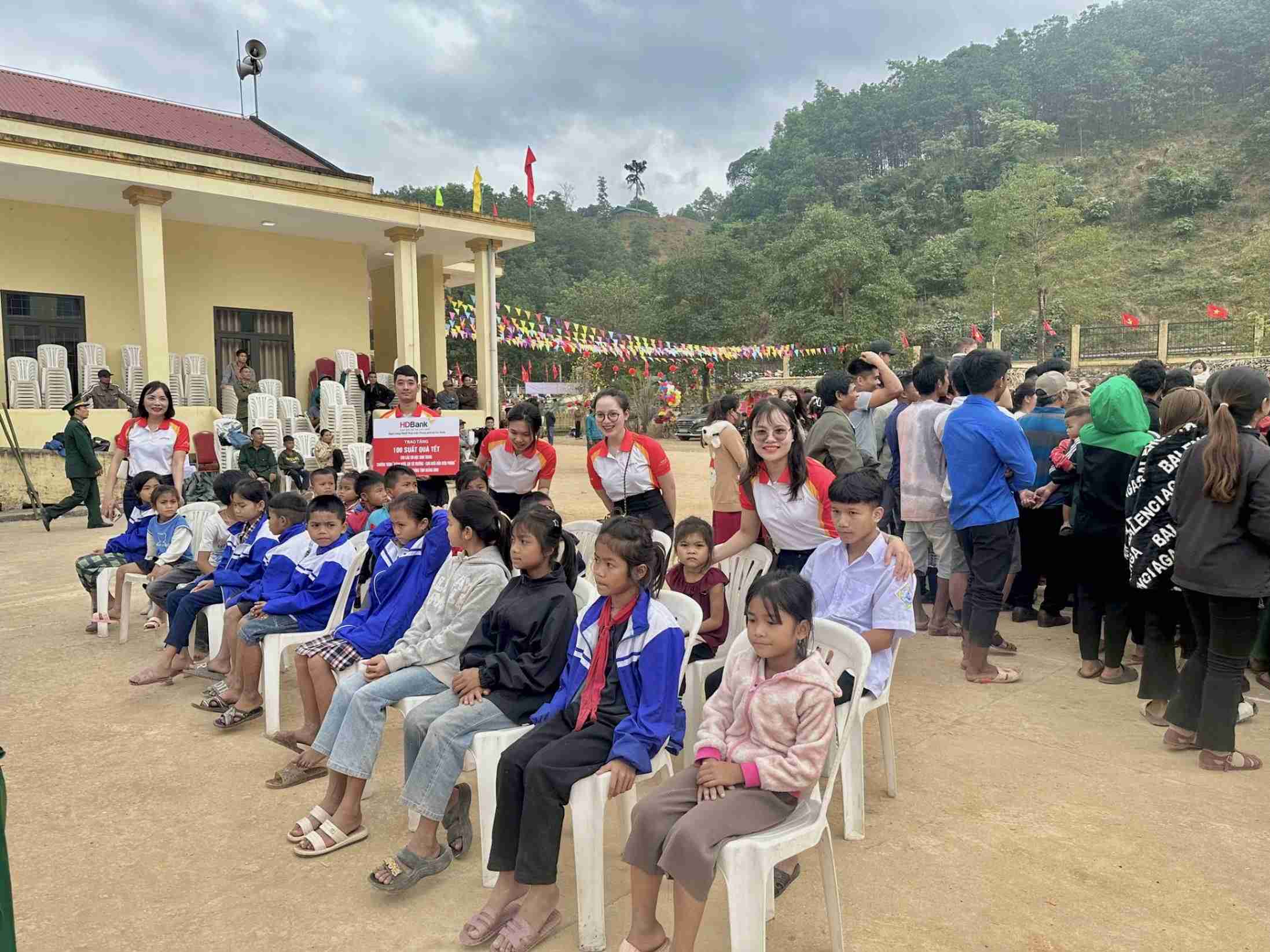 Kids seated at outdoor community gathering