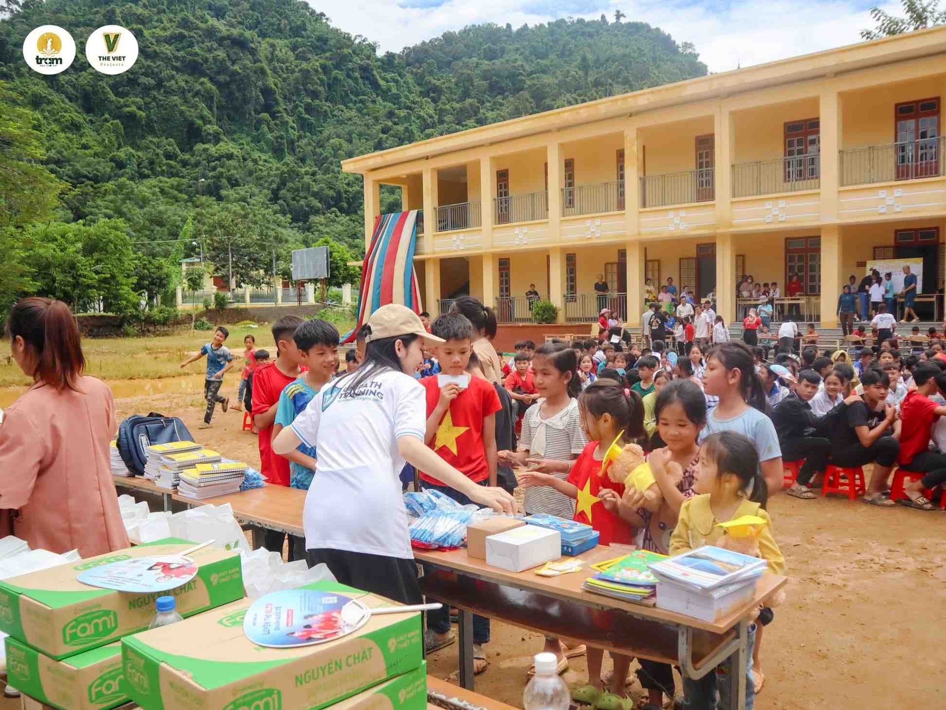 Children receiving educational gifts outdoors