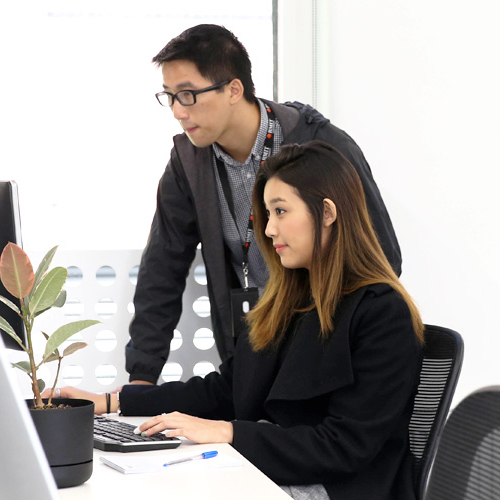 Intern working on computer with manager