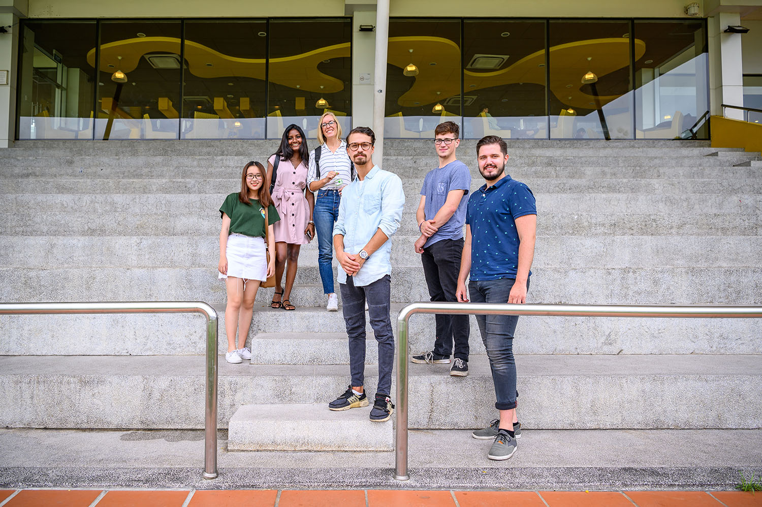 international students sitting and chatting on white stairs