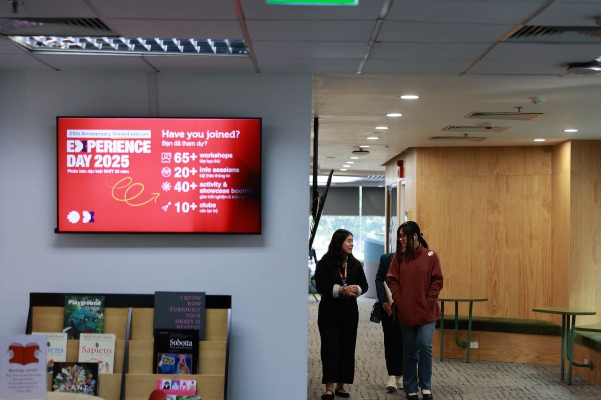 The photo showing 3 girls walking inside a building, talking to each other. 