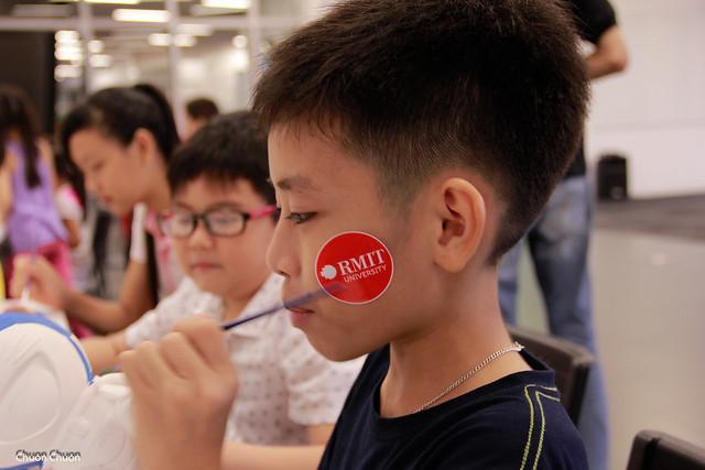 A child enjoys painting a statue at Saigon South campus